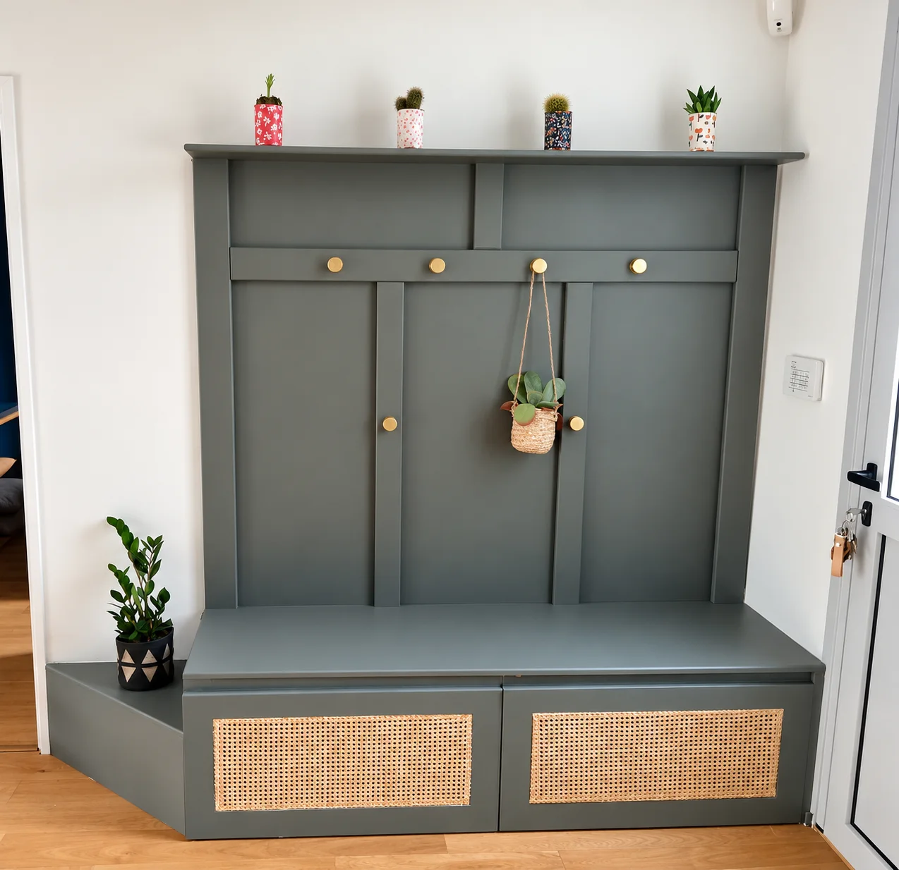 Meuble d’entrée peint avec banquette en bois, portes en cannage et patères